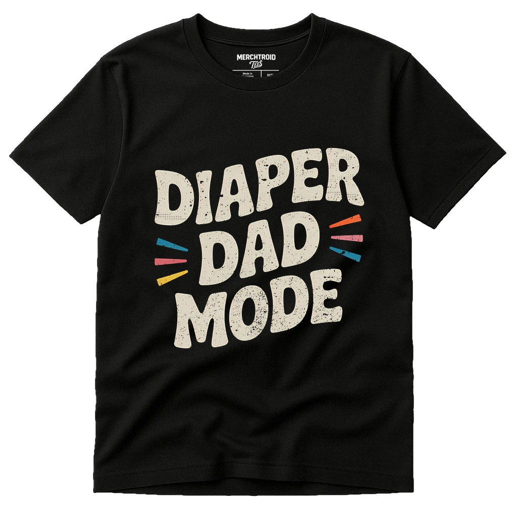 A black T-shirt with the text "DIAPER DAD MODE" printed in large, bold white letters. Surrounding the text are small colored lines in red, yellow, blue, and orange.