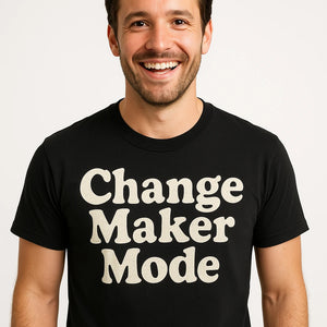 Close-up of the "Change Maker Mode" beige print on a premium Bella+Canvas black activism shirts