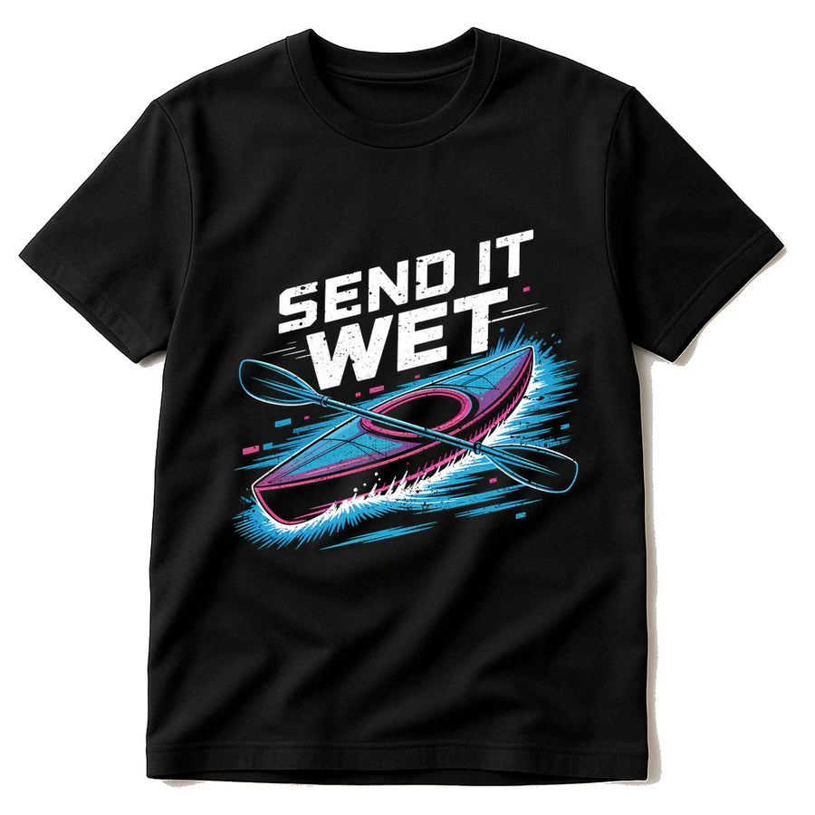 A black t-shirt featuring a graphic design of a kayak with crossed paddles. The text "SEND IT WET" is printed above the kayak in bold, white, distressed lettering. The kayak and paddles have pink and blue accents, with dynamic water splashes surrounding them.