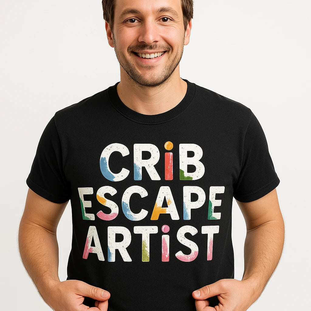 A person wearing a black T-shirt with colorful text. They are smiling and holding the sides of the shirt with their hands.