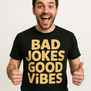 Close-up of the "Bad Jokes Good Vibes" tan print on a premium Bella+Canvas black comedy t shirt