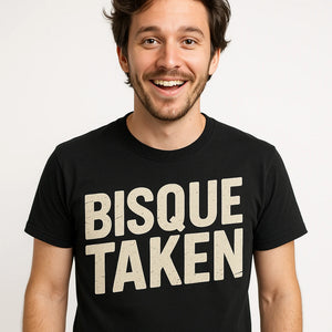 Close-up of the "Bisque Taken" beige print on a premium Bella+Canvas black ceramic tee
