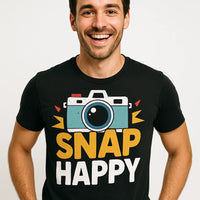 A person is smiling while wearing a black shirt with an illustration of a camera and the words 