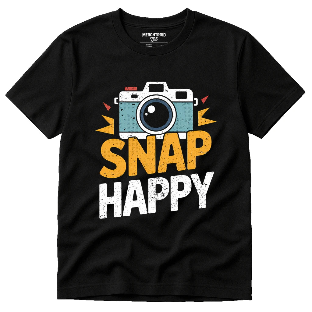 A black t-shirt featuring a colorful graphic of a retro camera above the phrase "SNAP HAPPY" in bold yellow and white letters. The camera design has vibrant accents, making the shirt visually appealing.