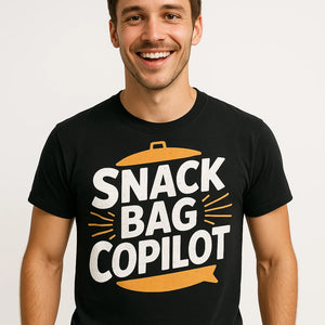 Close-up of the "Snack Bag Copilot" white print on a premium Bella+Canvas black road trip shirts