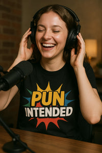 A person with curly hair is smiling while wearing headphones and a black shirt that says 