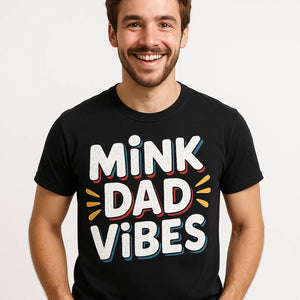 Close-up of the "Mink Dad Vibes" white print on a premium Bella+Canvas black mink t shirt