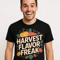 A person with a happy expression is wearing a black t-shirt with a colorful design of pumpkins and leaves, featuring the text 