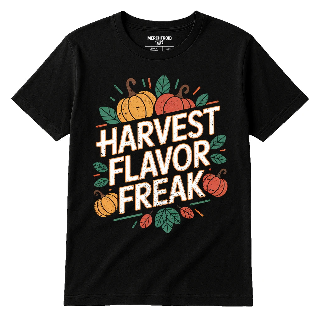 A black t-shirt featuring the text "HARVEST FLAVOR FREAK" in bold, distressed white letters. Surrounding the text are illustrations of pumpkins and leaves in orange and green colors, giving an autumnal theme.