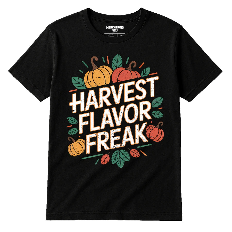 A black t-shirt featuring the text "HARVEST FLAVOR FREAK" in bold, distressed white letters. Surrounding the text are illustrations of pumpkins and leaves in orange and green colors, giving an autumnal theme.