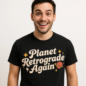 Close-up of the "Planet Retrograde Again" cream print on a premium Bella+Canvas black astrology shirts