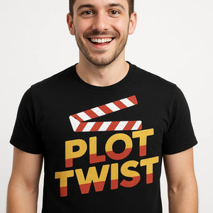 Close-up of the "Plot Twist" orange print on a premium Bella+Canvas black graphic tee