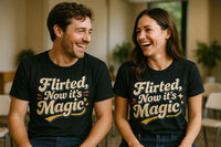A man and a woman sitting next to each other, both wearing black T-shirts with the text 