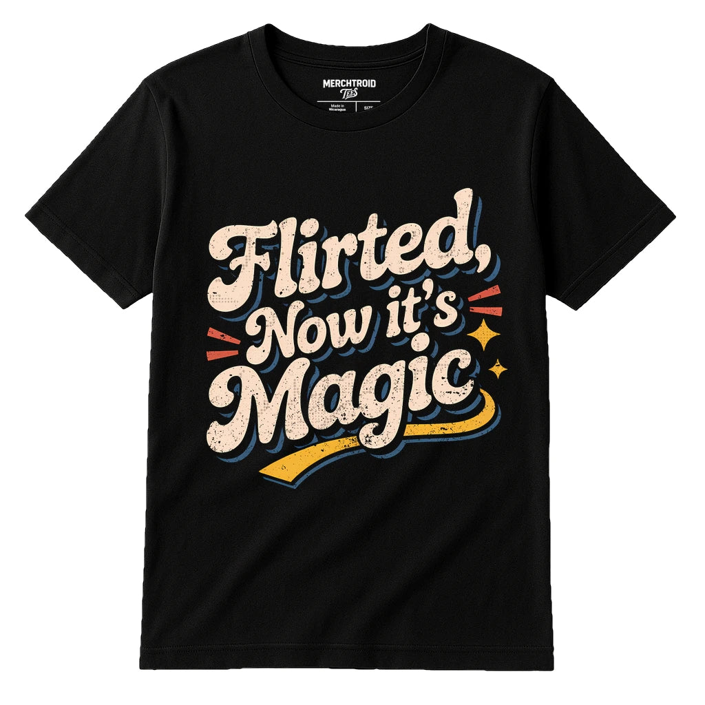 A black t-shirt with a vintage-style design featuring the text "Flirted, Now it's Magic" in a playful, bold font with decorative elements like stars and exclamation marks.