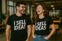 A man and woman are standing together, both smiling and laughing. They are wearing matching black t-shirts with the text 