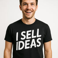 A smiling person wearing a black t-shirt with bold white text. The background is plain white.